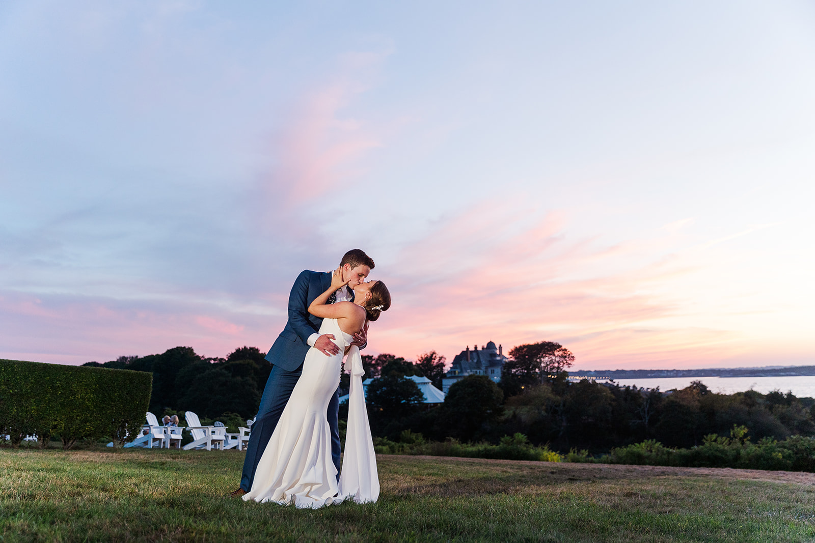 Bride and groom kissing at sunset on the lawn overlooking Narragansett Bay at OceanCliff in Newport Rhode Island