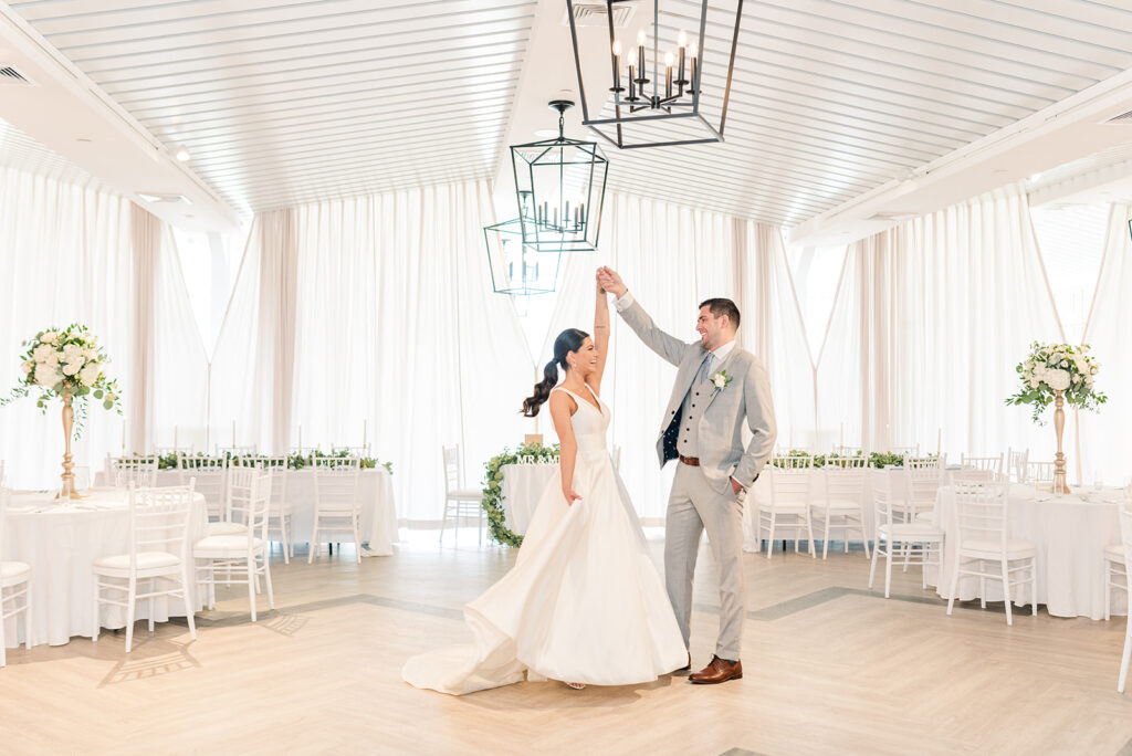 Newlyweds celebrating inside the light-filled reception space at Newport Beach House in Middletown