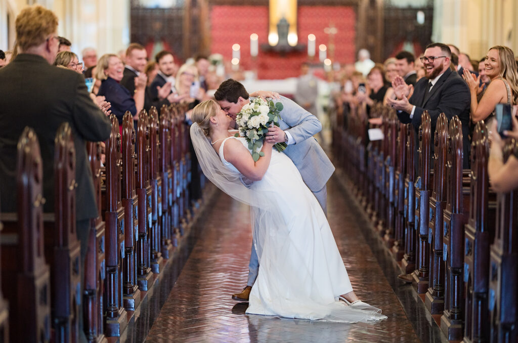 Bride and groom kissing in the aisle at St. Mary's Church wedding in Newport Rhode Island