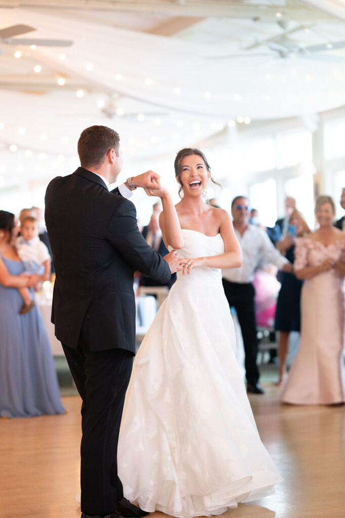 Bride smiling during first dance showing natural bridal hair and makeup by Shelby White Beauty