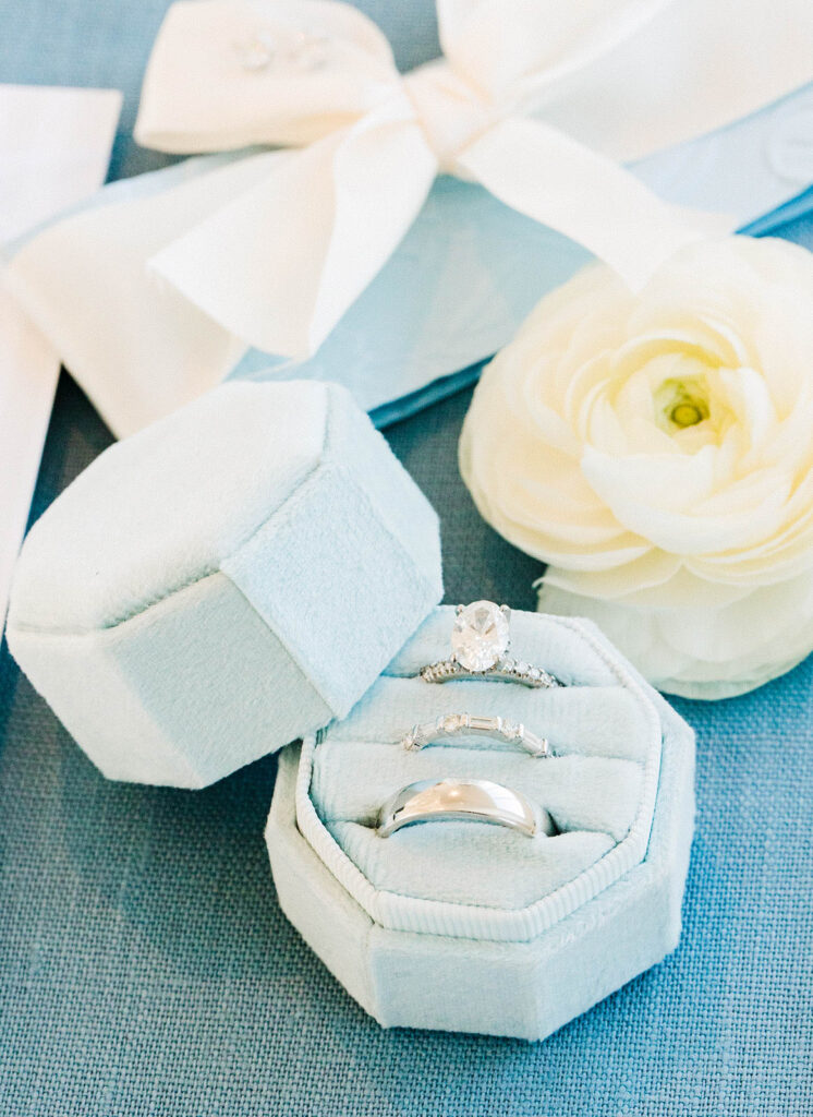 Wedding flat lay with invitation suite, rings, pearl jewelry, and bridal details at Belle Mer in Newport Rhode Island