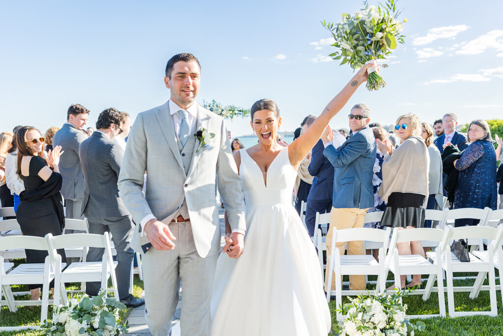 Bride and groom celebrating recessional at Newport Beach House oceanfront wedding ceremony