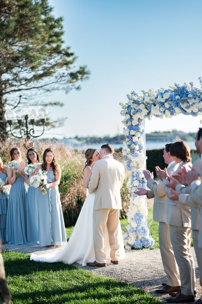 First kiss during waterfront wedding ceremony at Belle Mer in Newport Rhode Island