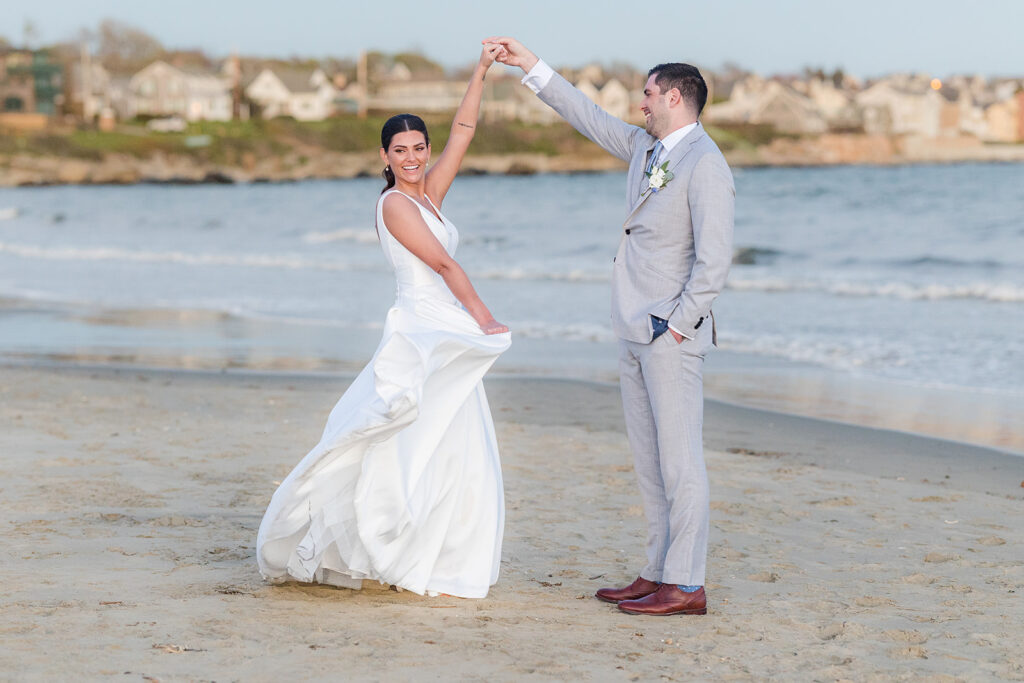 Bride and groom celebrating along the shoreline during portraits at Newport Beach House