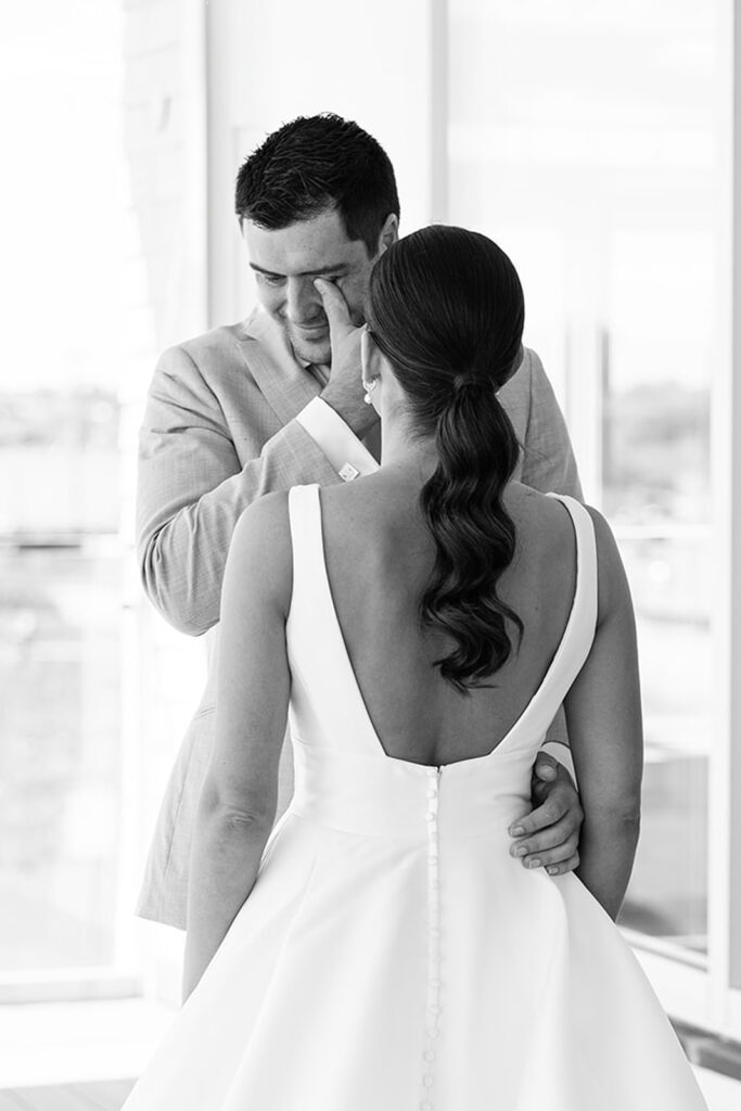 Emotional black and white image of couple embracing during their first look