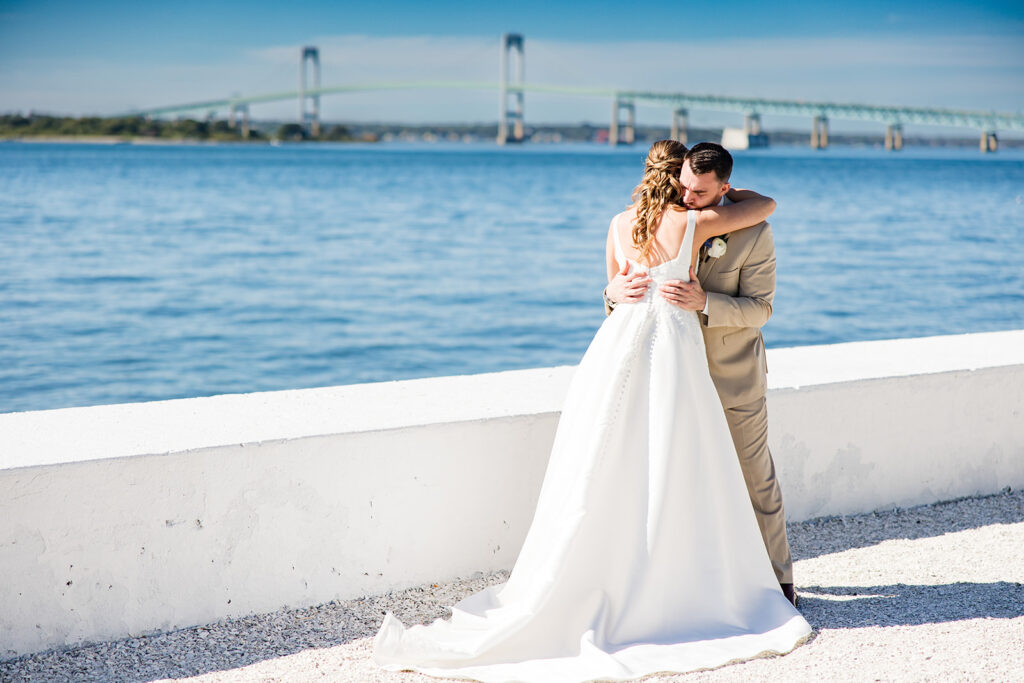 Bride and groom embracing after private vows on the Belle Mer waterfront overlooking Newport Harbor