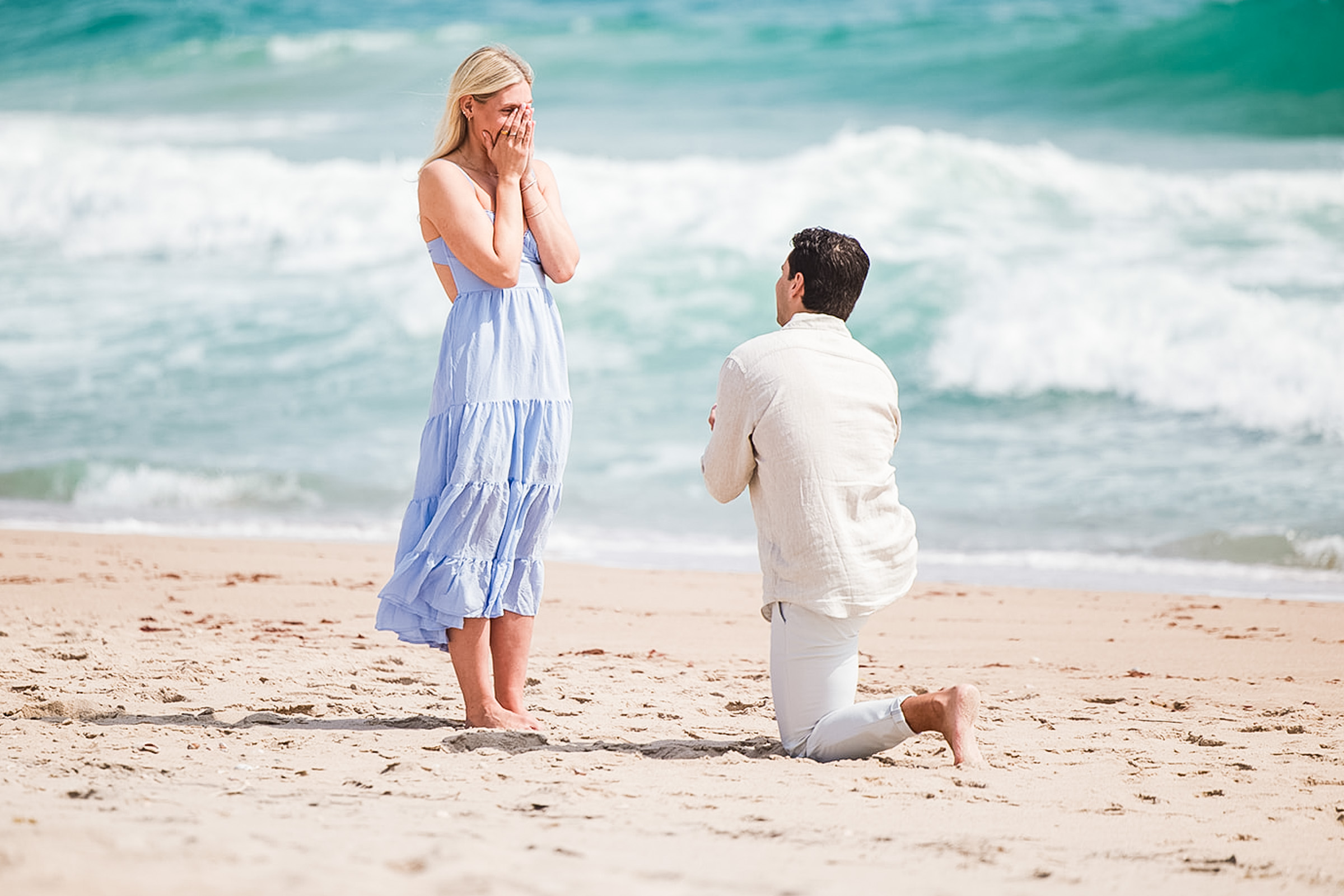 Romantic beach proposal in Rhode Island with ocean backdrop