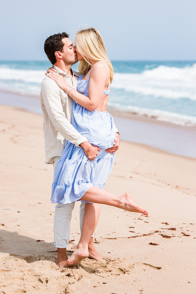 Romantic beach proposal in Rhode Island with ocean backdrop