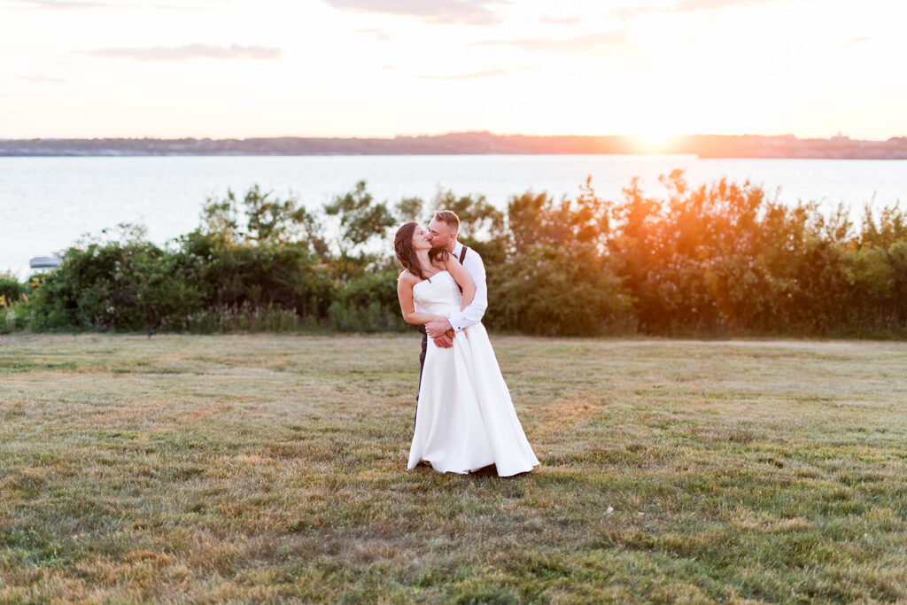 Newlyweds photographed with the sun setting over Narragansett Bay