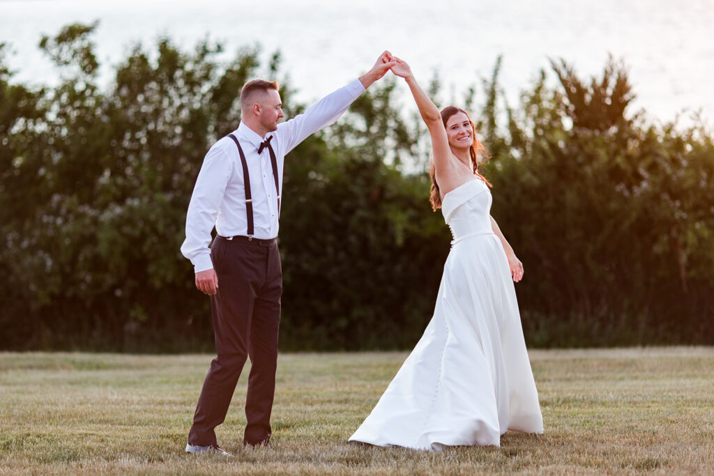 Bride and groom twirling during sunset portraits at OceanCliff