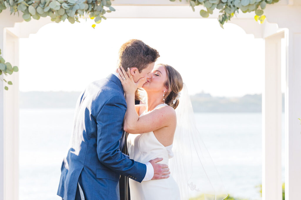 Bride and groom first kiss during their OceanCliff wedding ceremony