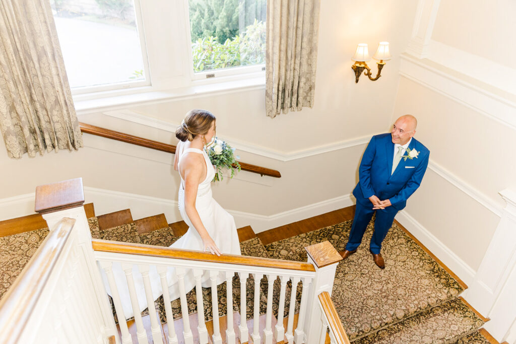 Bride walking down the staircase inside OceanCliff before her wedding ceremony
